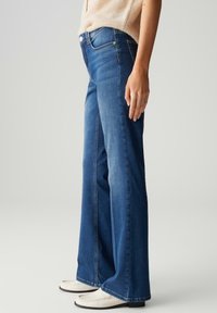 Wijduitlopende jeans in een middelmatige denimwas, met een hoge taille, klassieke vijf-pocket ontwerp en subtiele vervaging langs de benen.