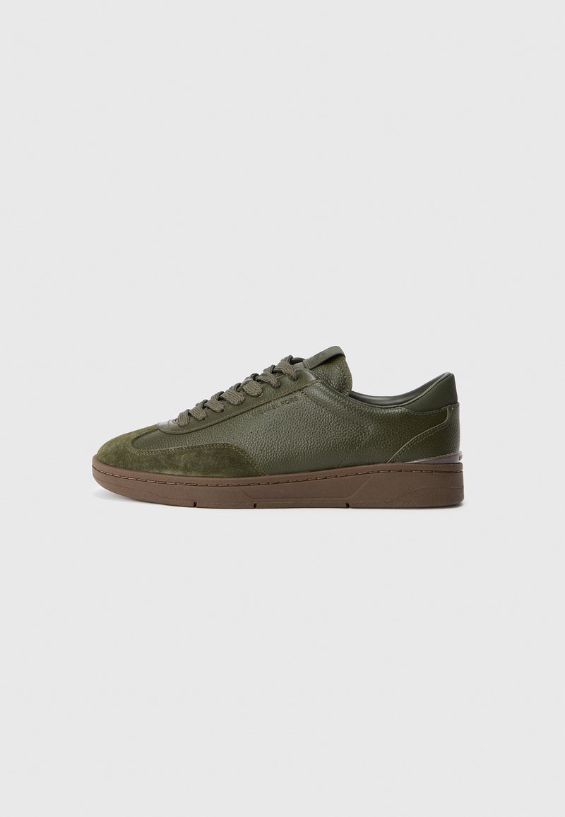 Olivgrüne Sneakers aus strukturiertem Leder und Wildleder, mit runder Zehenpartie, flachen Schnürsenkeln und einer braunen Gummisohle.