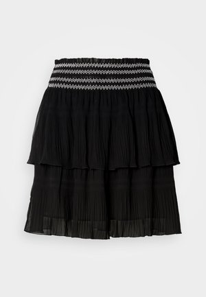 Schwarzer, gestufter Rock aus plissiertem Stoff. Mit einem gerafften Bund und weißem Zickzack-Stich. Leicht und fließendes Design.