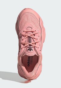 Scarpa da corsa rosa con tomaia in mesh e materiale sintetico, punta rotonda, chiusura con lacci, colletto imbottito e dettagli logo neri a contrasto.