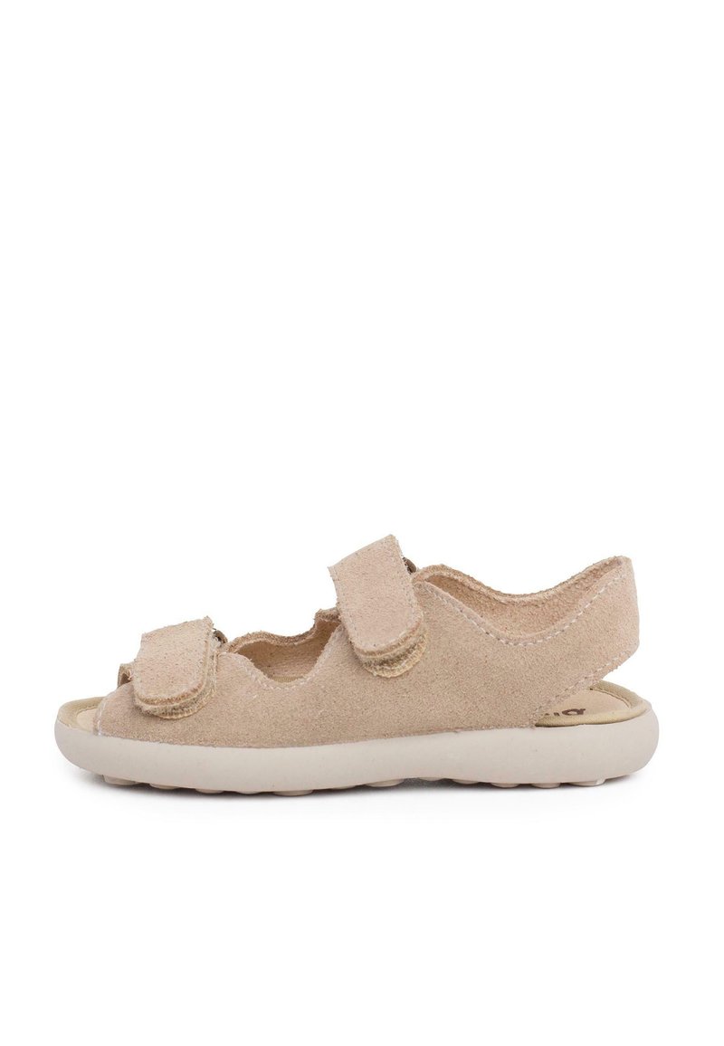 Beige suede sandal with two adjustable hook-and-loop straps, open toe, curved back, and a lightweight cream rubber sole.