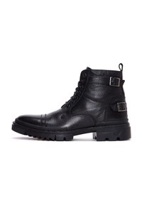 Botas de tobillo de cuero negro con parte superior texturizada, punta redonda, cordones delanteros y dos hebillas a los lados. Suela de goma gruesa con agarre.
