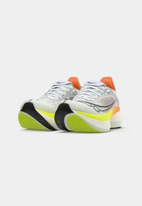 Des chaussures de course légères avec une tige en maille grise, un talon orange et une semelle extérieure jaune vif. Elles présentent une semelle texturée et des lacets blancs.