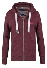 Czerwony melanżowy hoodie na zamek błyskawiczny z białymi sznurkami, przednimi kieszeniami, ściągaczami przy mankietach i u dołu, z logo na klatce piersiowej i wewnętrznej krawędzi kołnierza.
