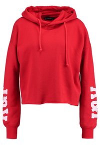 Felpa croppata rossa realizzata in tessuto morbido, con cappuccio e cordini, e scritte bianche lungo le maniche. Maniche lunghe e vestibilità comoda.