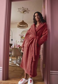 Fluffy, textured, deep pink robe with a tied waist and two pockets. Paired with white slippers featuring a red lobster design.