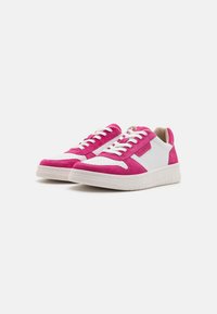Rosa mocka och vit lädersneakers med perforerat tå, vita snörningar och vadderat ankelsupport, med en lätt gummisula.