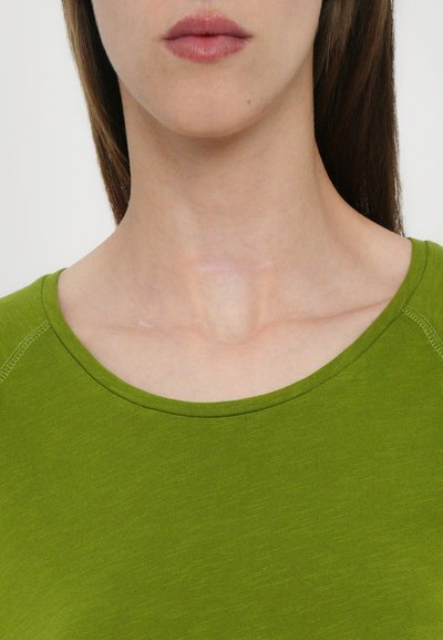 Green short-sleeve top featuring a round neckline, smooth texture, and subtle sheen. Close-up view reveals stitching details on shoulders.