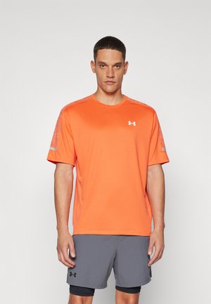 Oransje atletisk t-skjorte med korte ermer, med teksturerte skulderdetaljer og en liten hvit logo på brystet. Kombinert med grå shorts.