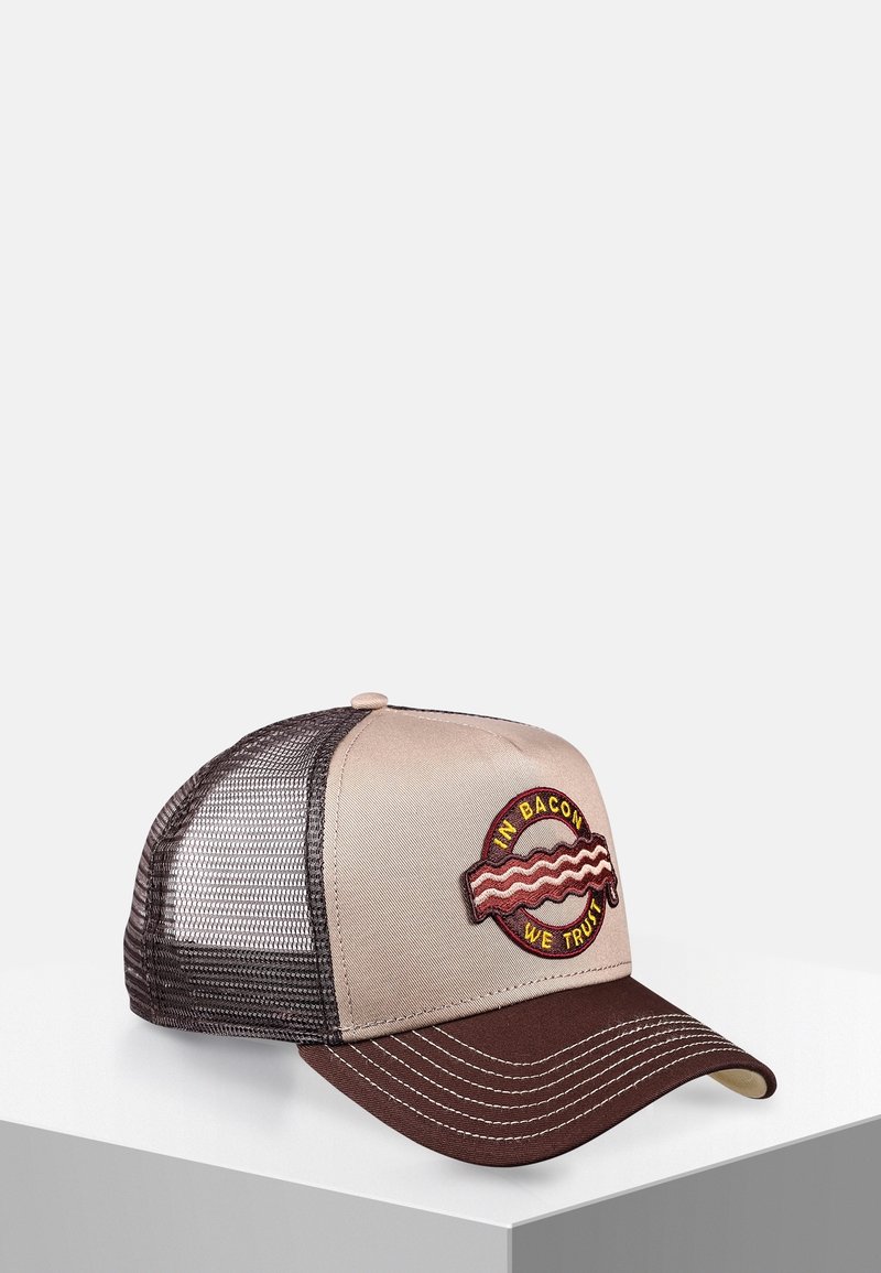 Casquette trucker beige et marron en mesh avec une visière incurvée et un patch montrant des tranches de bacon et le texte "In Bacon We Trust" sur le panneau avant.