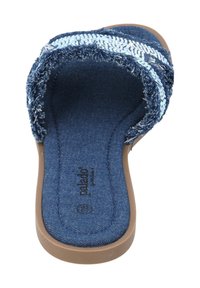 Denim slide sandal med en texturerad blå rem, med fransiga kanter och ett vadderat inre. Sulan är i ett slätt, ljust brunt material.