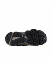 Suola di scarpa con motivo drenante nero e grigio, caratterizzata dal logo New Balance e zone di presa纹理.