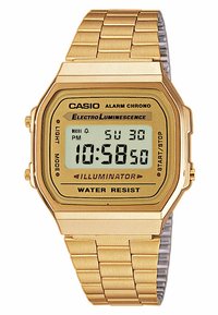 Montre numérique dorée avec un cadran rectangulaire, bracelet en acier inoxydable, affichage LCD, et fonctions d'alarme et d'illumination. Résistante à l'eau.