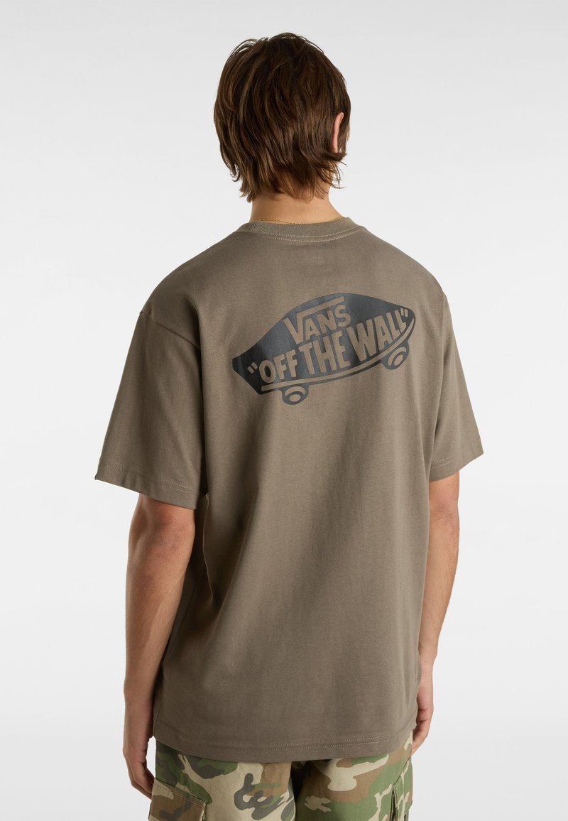 Khaki t-shirt made of cotton with a relaxed fit. Features a large black "VANS OFF THE WALL" graphic on the back.