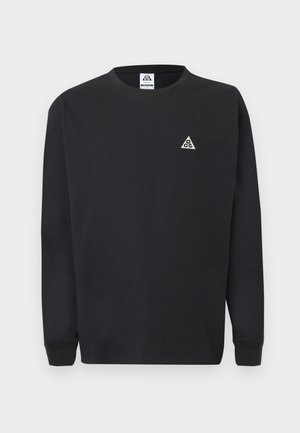 Črna majica s kapuco z dolgimi rokavi, z majhnim belim trikotnim logotipom ACG na levi strani prsnega koša in usklajenim etiketo znotraj ovratnika.