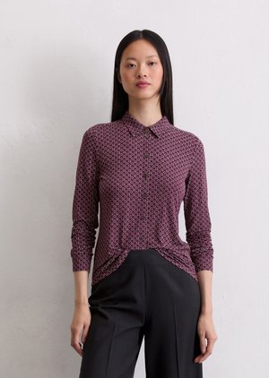 Maroon, patterned blouse with a collared neckline, long sleeves, and a button front. Fabric appears smooth with a subtle texture.