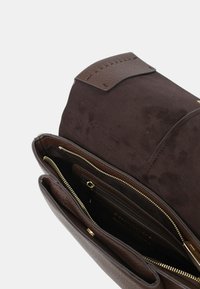 Borsa a mano in pelle marrone con superfici lisce e testurate, dotata di dettagli con cerniera color oro e molteplici scomparti interni per l'organizzazione.