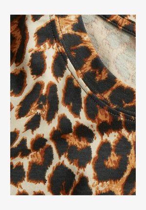 Leren stof met een panterprint in oranje en zwarte vlekken op een beige achtergrond; soepele textuur met een ronde halslijn en zichtbare naaddetails.