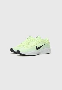 Baskets Nike jaune néon avec un swoosh noir, tige en mesh, fermeture à lacets, col rembourré, semelle intermédiaire blanche et semelle extérieure en caoutchouc noir texturé.