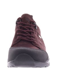 Bruine suède wandelschoen met een zwarte rubberen neus, rode patroonveters en logo op de tong. Voorzien van een gestructureerde zwarte rubberen zool.