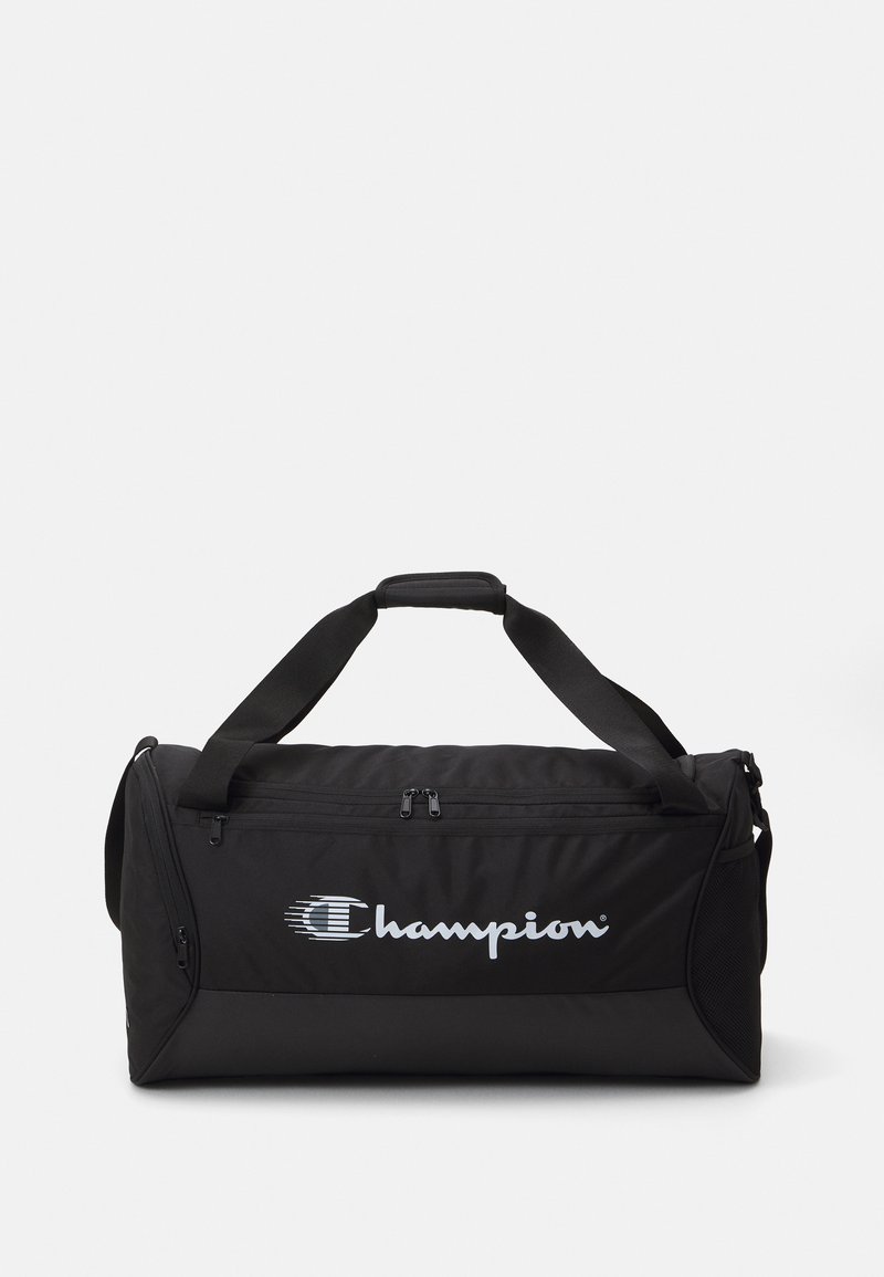 Bolsa de deporte negra hecha de un tejido resistente, con un compartimento principal con cremallera, asas para llevar y un logo destacado de Champion.