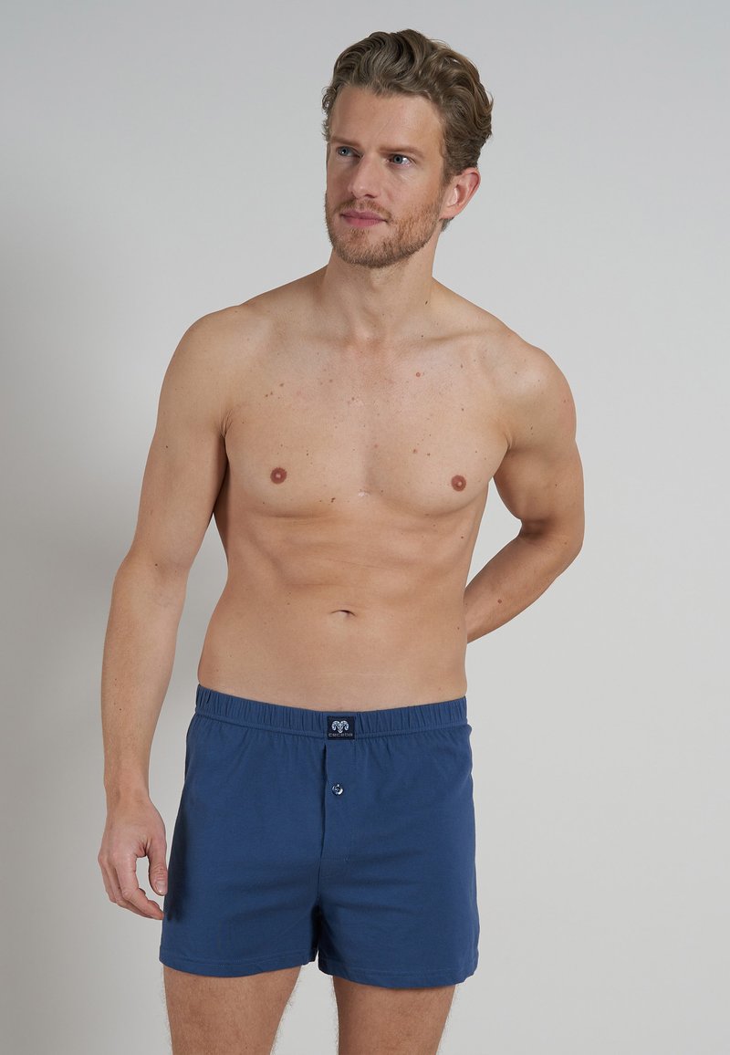 Boxer shorts en coton bleu marine avec une taille élastique, dotés d'une fermeture à bouton et d'un petit logo sur le devant.