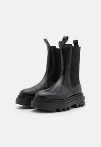 Zwarte leren chelsea boots met elastische zijpanelen, stevige textuurzolen en aantreklussen voor gemakkelijk aan- en uittrekken. Glad afwerking en duurzame ontwerp.