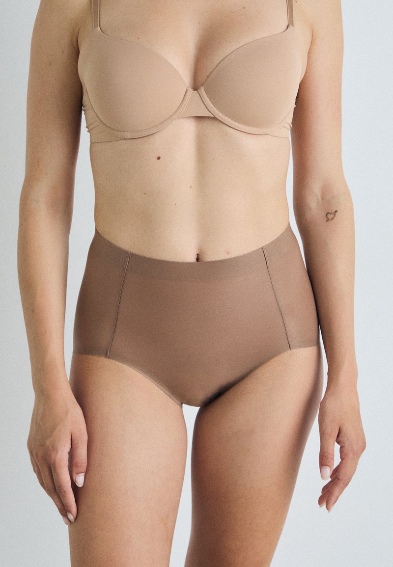 Chiloți cu talie înaltă, de culoare maro cocoa, fabricați dintr-un material elastic neted, cu un design fără cusături și o talie moale.