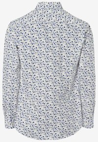 Chemise blanche à manches longues avec un petit motif floral bleu et beige, dotée d'un col classique et de poignets boutonnés, vue de dos.