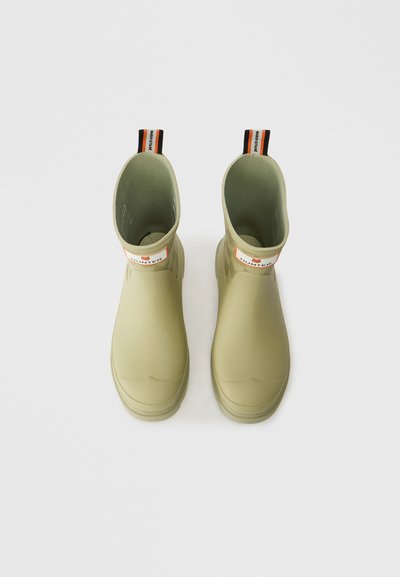 Zelene gumene škornje za dež, z gladko teksturo, do sredine meč, s kontrastnim oranžnim in črnim izvlečnim trakom ter logotipom na sprednji strani.