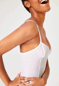 Witte aansluitende bodysuit met dunne bandjes, naadloos ontwerp, gladde textuur en contoured silhouet dat de lichaamsvorm accentueert.