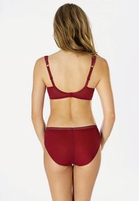 Burgunderfarbenes Wäscheset bestehend aus einem nahtlosen BH mit verstellbaren Trägern und passendem Slip, beide aus glattem Material mit einem weichen Finish.