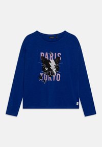 Long-sleeve blue t-shirt featuring a black cat graphic, pink text saying "PARIS TOKYO," and silver accents for added detail.