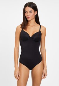 Schwarzer Bodysuit mit gepolsterten Cups, verstellbaren Trägern und einem zentralen Schleifendetail. Glatte Stoffbeschaffenheit mit passgenauer Silhouette.