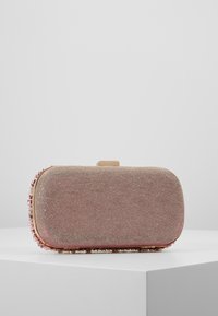 Sac à main rectangulaire en tissu rose doux avec une texture côtelée, orné de petites perles le long du bord et d'un fermoir doré.