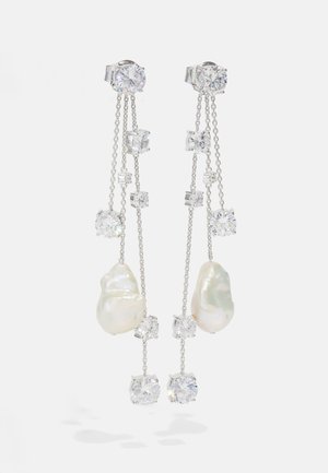 Ασημένια σκουλαρίκια με σταγόνες που διαθέτουν ανώμαλα λευκά μαργαριτάρια, καθαρούς ζιρκόνους και λεπτές αλυσίδες διαφόρων μηκών.