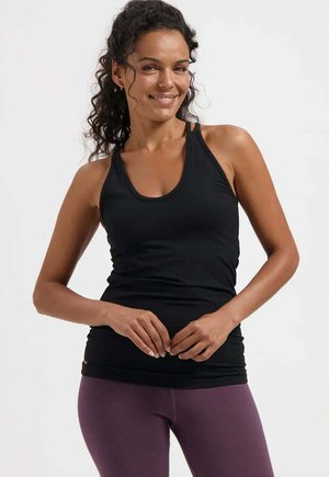 Débardeur de sport noir sans manches avec encolure ronde, coupe ajustée et texture lisse, associé à un legging violet taille haute.