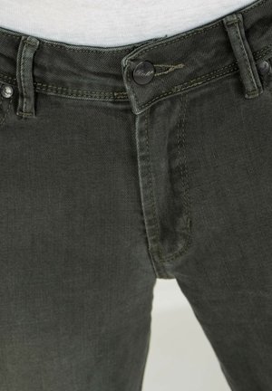 Dark green denim pants with a zip fly, button closure, and five-pocket design. Features contrasting stitching and a faded texture.