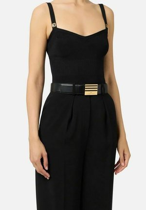 Body a coste nero con spalline regolabili e dettagli dorati. Abbinato a pantaloni neri a vita alta e cintura nera con dettaglio dorato.