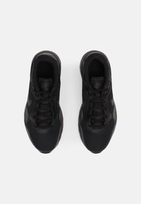 Baskets de sport noires avec tige en mesh, design à lacets, col rembourré et semelle extérieure texturée. Marquage discret sur la languette et les côtés.