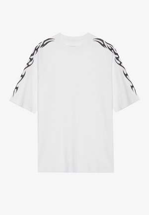 Hvit bomull T-skjorte med korte ermer. Har svarte flamme mønstre langs skuldrene. Klassisk rund hals design. Glatt tekstur.
