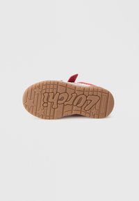 Red felt shoe with a rubber sole featuring star patterns and embossed branding. The design includes a soft upper with a rounded toe.