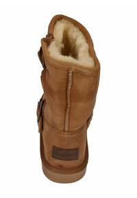 Bruine suede enkelboot met een zachte, crèmekleurige voering, een platte zool en een leren label met "Warmbat" aan de achterkant.