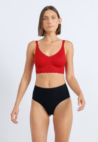 Piros kötött bralette széles pántokkal és fodros szélekkel, magas derekú fekete bugyival párosítva, sima textúra, minimalista dizájn.
