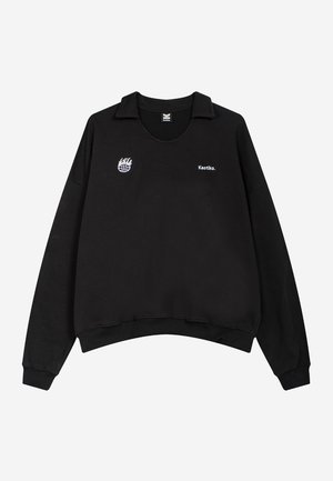 Black sweatshirt with a polo collar, featuring a logo and text "Kaotiko." on the left chest; made of soft fabric with a relaxed fit.