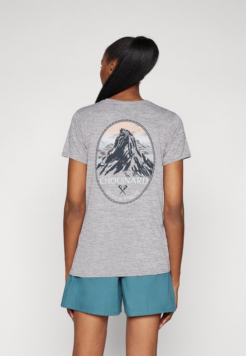 Γκρι κοντομάνικο μπλουζάκι με γραφικό βουνού στην πλάτη, και το κείμενο "CHOUINARD" και "BUILT TO ENDURE" υπό μια κυκλική σχεδίαση.