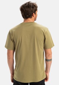 Olivenfarvet kortærmet t-shirt lavet af blødt stof, med en klassisk rund halsudskæring. Glat tekstur med minimale syninger.