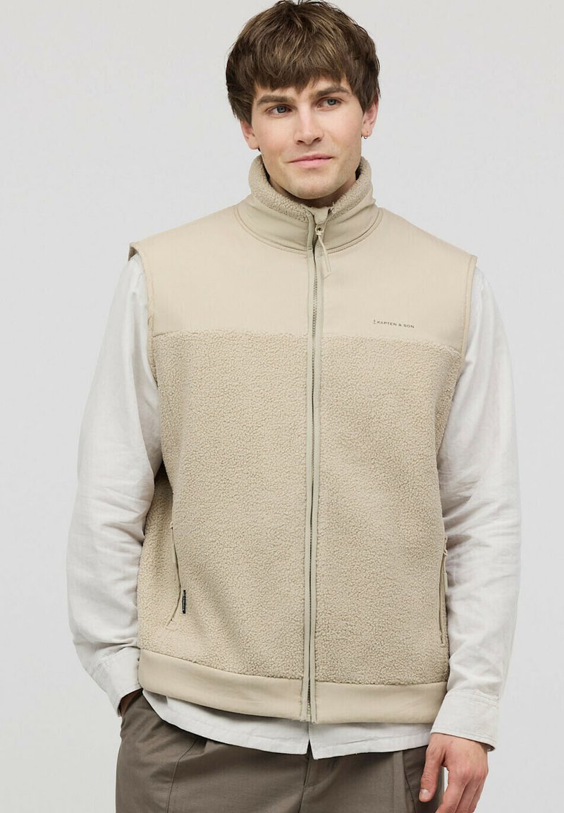 Helle beige Weste mit einem Fleece-Unterteil und glattem Obermaterial. Verfügt über einen hohen Kragen, einen durchgehenden Reißverschluss und Seitentaschen.