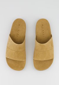 Sandales à glissière en daim beige avec un design de sangle large qui se chevauche et une semelle intérieure rembourrée. Présente une texture lisse et des détails de couture minimes.