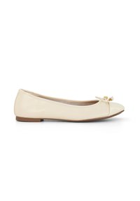 Ballerines en cuir verni beige avec un bout arrondi, un détail de nœud à l'avant, et une semelle plate marron. Texture lisse dans l'ensemble.